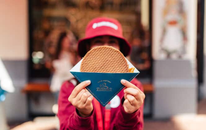A person holding a waffle in a blue package. Delicious food in Amsterdam