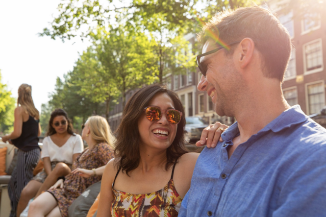Happy couple on a sunny day in Amsterdam. Young tourists enjoying the city.