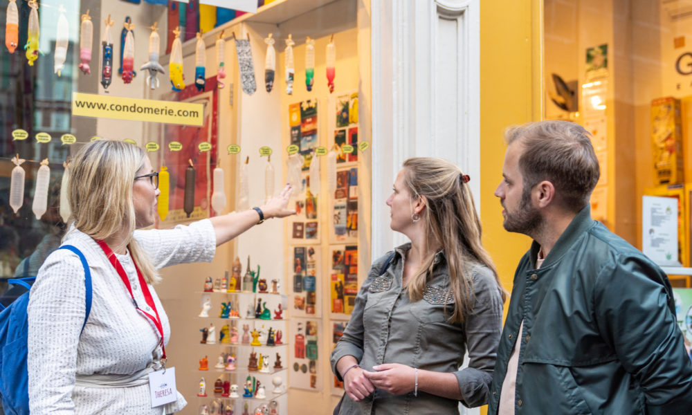 Tour guide explaining Amsterdam landmarks to tourists. Happy travelers exploring the city.