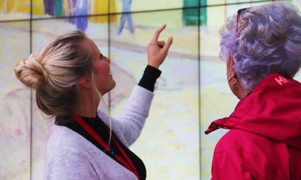 Two women looking at interactive art. Woman pointing to screen.