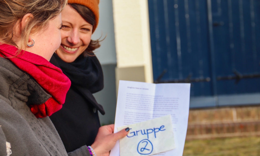 Two women on a city trip looking at a map. They are smiling and planning their day.