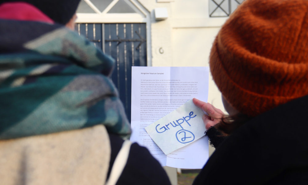 Hand holding a tourist map and brochure. A great guide for your Amsterdam city trip.