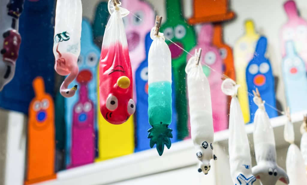 Preservativos de distintos colores colgados de una cuerda en la Condomerie de Ámsterdam