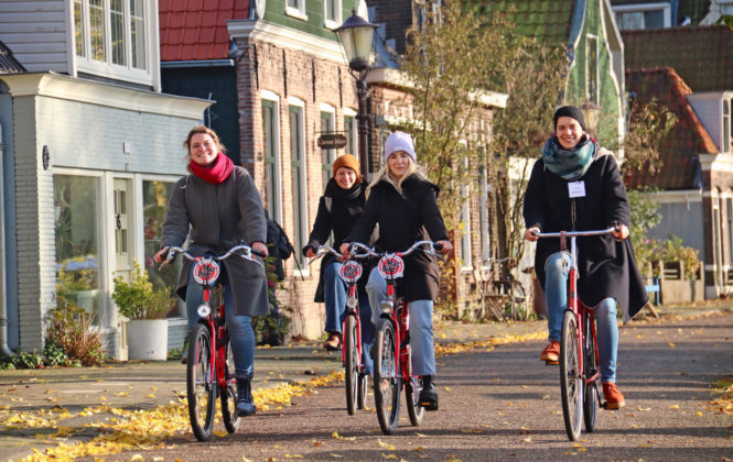 Amsterdamliebe Teilnehmer Fahrradtour während Firmenreise in Amsterdam