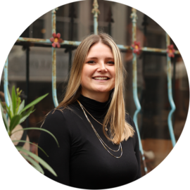 A smiling woman with blonde hair on a city trip. Enjoying Amsterdam.